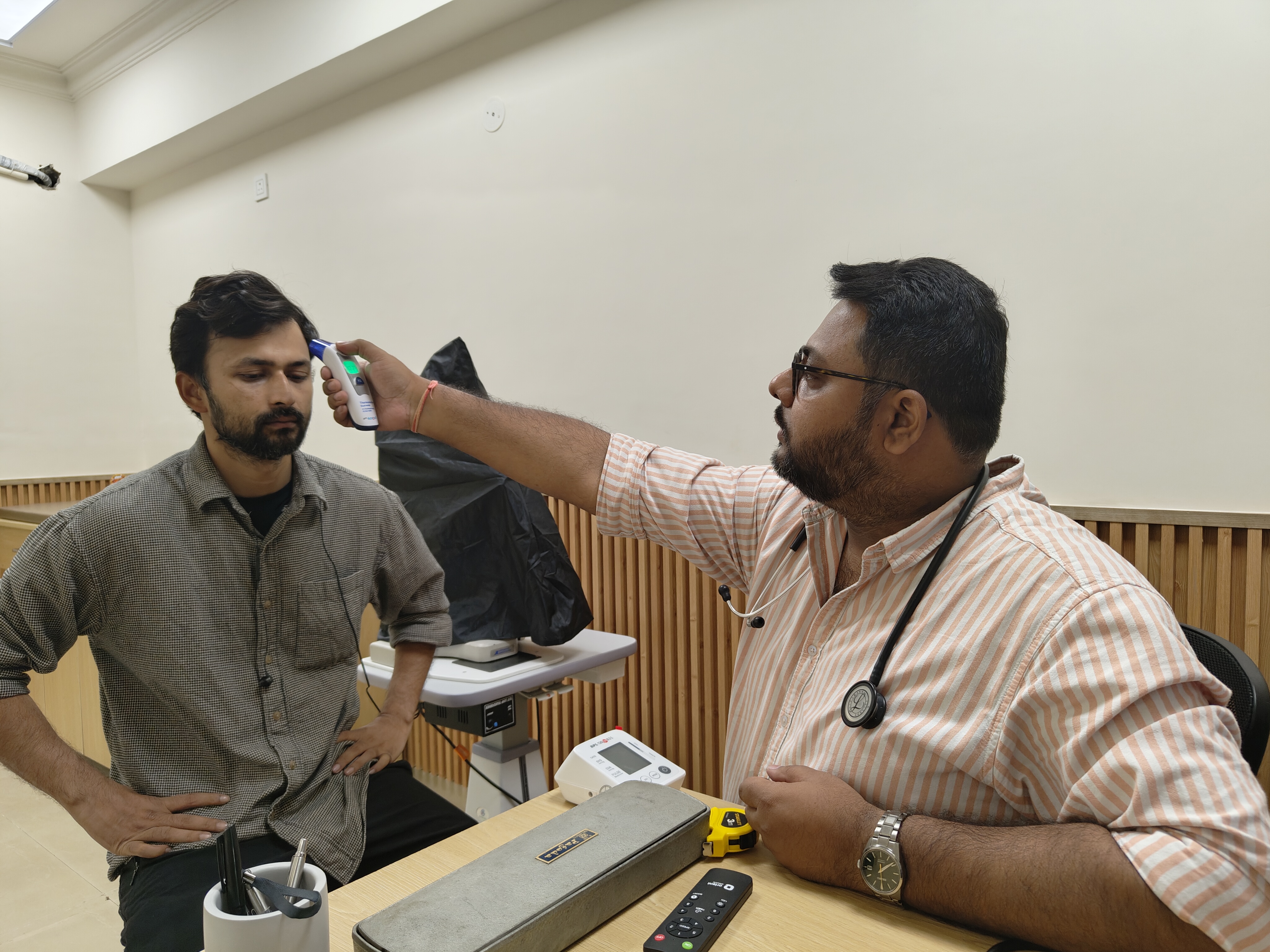 Dr. Prateek Shujanya checking a patient's temperature at our family health clinic in Indirapuram, Ghaziabad
